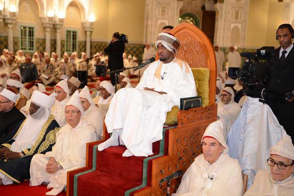 La coopération entre le Royaume du Maroc et les pays Africains en matière de protection contre l’extrémisme et le terrorisme .[1]  Grâces soient rendues au Seigneur des Mondes !  Et que la prière d’Allah et Son salut soient appelés sur le Seigneur des Messagers, ainsi que sur les Siens et ses Compagnons les plus nobles.  Mon Seigneur, Commandeur des croyants !  Il est pour moi un insigne honneur de présenter cette causerie ci-devant Votre Présence qui nous couvre de son ombre ; en cette Nuit bénie, et dans le cadre de cette série scientifique sertie d’or ; la série des Causeries hassaniennes qui symbolisent une manifestation raffinée de Votre coutumière tradition de veille à la diffusion du savoir scientifique en général, et de la sensibilisation religieuse en particulier. Et ce, partant de Votre responsabilité de Commandeur des Croyants, issue de la mission de protection de la Religion et de la foi partagée ; et en vertu de l’allégeance prononcée par l’Oumma, sur foi de la protection des finalités ultimes de la Chariâa et qui consistent en la préservation de la religion, de la vie, de l’ordre général, de la justice et de la dignité de l’homme.  Cette causerie a pour sujet une question d’une grande importance en ce temps actuel ; relative aux possibilités de coopération entre Votre Royaume chérifien et les autres pays d’Afrique, dans le domaine de la prévention contre la pensée du terrorisme; cet esprit qui voudrait se construire en fondant sur la falsification des textes religieux.  Pour ainsi faire, nous avons composé la causerie en une présentation, suivie de trois axes. Dans la présentation, nous commencerons par expliquer le verset qui sert d’argument à la causerie, et qui est en l’occurrence: «Soyez plutôt solidaires dans la charité et la piété et non dans le péché et l’agression. Craignez Allah, car Allah est redoutable quand il sévit». [Al-Mâ’ida ‘la Table’ :3]  Dans le texte coranique, al-birr, signifie: la recherche de l’accomplissement des meilleures bonnes œuvres, ainsi que de la satisfaction et du bien achevé et intégral.  At-taqwâ, est le substantif nominal du verbe ittaqâ: il signifie « se méfier de quelque chose, de crainte qu’il ne soit dangereux ». Dans le vocabulaire de la Chariâa, ce mot est mis pour la crainte du châtiment d’Allah, en obéissant à ses ordonnances, et en évitant ses interdits.  L’homme pieux, celui qui craint Allah, est donc celui qui, avisé, cherche à échapper à tout ce qui pourrait être infâme et nuisible.  Le verset signifie donc: votre devoir, ô vous les croyants, de vous entraider pour faire le bien et pour craindre Allah. Le sens de « s’entraider » est de faciliter l’accomplissement des œuvres, de favoriser les bienfaisances et de montrer un esprit d’alliance et de soutien réciproque; afin que tout cela devienne une éthique généralisée à l’ensemble de l’Oumma.  Et que le verset dise: « et ne vous entraidez pas dans le péché et l’agression», corrobore le sens de « entraidez-vous dans la piété la meilleure et dans la crainte d’Allah». Car, ici, il s’agit d’ordonner une chose, même si le verset notifie implicitement l’interdiction de son contraire, puisque quand l’intérêt est porté au contraire, il signifie que l’on vise spécifiquement une interdiction.  L’entraide pour le meilleur des biens obéit à la même règle que tout ce qui pourrait servir la religion. Nous en entendons ici la protection contre la pensée terroriste; en considérant que tout ce qui a été interdit par Allah, le péché et la transgression, ne doit pas faire l’objet d’une entraide, tel que le terrorisme l’illustre par sa brutalité et par ses compromissions.  Et pour accéder au vif du sujet, nous nous interrogeons: quel en est le fond? Il s’agit de l’exigence sociale, qui est la priorité suprême dans la vie des Musulmans, que ces derniers puissent vivre leur vie religieuse. Ils ont besoin, à cet effet, de connaître la science de la religion pour accéder à une compréhension scrupuleuse de son sens. Tout comme ils ont besoin d’apprendre ce que ses piliers et transactions réalisent dans le domaine de l’encadrement et de la préparation intellectuelle et logistique. Il est supposé de quiconque prend en charge les affaires des Musulmans, comme c’est justement le cas de la Commanderie des croyants au Maroc, de répondre à ces besoins. Et, grâces en soient rendues à Allah, c’est elle qui prend en charge cette réponse, la gère, la contrôle et la protège. Et il suffit d’une seule brèche, dans cette réponse ou dans cette prise en charge, pour que la pensée de l’extrémisme et du terrorisme en profite de la pire des façons.  Malgré que certains pays d’Afrique ne remplissent pas cette condition, pour des raisons nombreuses, dont le choix d’une constitution laïque, la coopération du Royaume du Maroc avec eux est une responsabilité et un devoir religieux, faisant partie intégrante des droits de fratrie et des proches parents, prorogeant des liens établis depuis fort longtemps et préservant les leviers d’un destin commun.  Premier axe : les constantes partagées sont une défense contre l’esprit du terrorisme Les constantes religieuses sont ce que nos aïeux ont choisi relativement au dogme, à la doctrine et au comportement spirituel. S’y attacher se faisait en parfaite harmonie avec la vie des Musulmans en Afrique. Cet attachement constituait, tout au long des siècles, une protection de la Religion contre l’esprit de l’immodération et de l’extrémisme. L’institution de ces constantes, à l’origine, pour un certain nombre de pays, était associée à la relation au Royaume du Maroc. Particulièrement, à travers la relation aux référents des machiakhas scientifiques et soufies. Les relations étaient plénières et interactives, et elles ont concerné l’élément humain autant que l’échange commercial et culturel. Du flanc même de ces relations sont nées les constantes religieuses partagées, qui sont l’achâarisme pour le dogme, le malékisme pour la doctrine et le soufisme en tant que pratique spirituelle. Ceci signifie que l’entraide n’est pas née d’aujourd’hui, bien qu’elle soit confrontée à des nouveaux défis.  Le dogme achâarite Le dogme achâarite revêt donc une importance particulière du point de vue politique, à notre époque, car il est fondé sur le principe que le Musulman, dès qu’il a attesté verbalement de l’existence unique d’Allah et de la foi en cette unicité, et dès qu’il a confirmé que Mohammad est Son messager, devient un croyant. Et par conséquent, nul n’a le droit de l’excommunier, sous prétexte de pratique insuffisante, ou sous aucun autre prétexte. Car, si ce Musulman devait avoir une pratique discutable envers lui-même, la responsabilité lui en incombe et il n’en est redevable qu’à lui-même. Et s’il devait transgresser les droits d’autrui ou de la communauté, il en est redevable à la justice; et si, enfin, il devait contrevenir à une obligation entre lui et Son Dieu, il revient à Allah seul de le traiter selon Sa justice, s’Il en décide ainsi, ou par Sa faveur, si ainsi Il le décide. La question du dogme, comme on le sait, n’a pas beaucoup attiré l’attention du commun des gens, jusqu’à ce que l’affaire des takfiriyyines (excommunionistes) se soit aggravée à notre époque; pour cela donc, le partage du même dogme et sa défense sont des éléments de l’entraide dans la protection contre la pensée terroriste.  La doctrine malékite Quant à la doctrine malékite, elle se spécifie par trois points, qui ont aussi leur importance politique, et qui sont :  La richesse de sa démarche dans la déduction des commandements à partir des textes; et c’est ce qui explique l’importance de l’initiative raisonnée (al-ijtihad) pour cette doctrine; L’importance que le malékisme donne à l’intérêt général, et qui un lien direct avec la régularité des lois ; La décision de considérer, comme ressources, les pratiques courantes antérieures; et c’est la voie majeure pour lever la prétention de l’hérésie à propos de beaucoup de pratiques culturelles dans les pays Africains. Les effets constatés de l’ancrage solide de l’unité doctrinaire dans les pays d’Afrique à partir du Maroc ont conduit le chercheur John Hunwick, qu’Allah l’ait en Sa sainte Miséricorde, à dire du malékisme qu’il était le « don du Maroc à l’Afrique ». Ce en quoi il a parfaitement raison, pour les considérations suivantes:  L’ordre général a besoin d’un paradigme de référence doctrinaire; car les divergences entre doctrines, bien qu’elles soient centrées sur des questions partielles, pourraient être utilisées dans l’embrouillement des esprits ordinaires, qui ont tendance à tant les grossir qu’elles prennent l’allure de vérités par lesquelles on voudrait combattre le non avenu; L’unité doctrinaire est une garantie de sérénité, particulièrement dans les mosquées; L’adoption par un État d’une doctrine est suivie par l’appui des ouléma, sur cette base convenue que les finalités de la Chariâa s’accomplissent par le perfectionnement continu. Ici nous devons indiquer la relation organique se trouvant entre la réforme politique et la prédication de la religion. Si la politique devait être défaillante en termes de réformes, il serait difficile aux prédicateurs de convaincre les gens et de les faire adhérer à des valeurs qui sont à même de repousser le trouble (fitna); et si, parallèlement, les affaires de la prédication, c’est-à-dire la gestion des affaires religieuses, devaient être mises en panne, elles perturberaient la politique; à cause de la propagation d’interprétations extrémistes, qui assurément mettront à mal tout effort de réforme. Le soufisme Quant à la troisième constante religieuse partagée avec les pays Africains, elle consiste en la pratique spirituelle connue sous le terme de soufisme. Faut-il rappeler que la majorité des prédicateurs et des commerçants Marocains en Afrique étaient des chadilites depuis le Septième siècle de l’Hégire? Jusqu’à la rénovation du mouvement soufi par les soins des disciples du Cheikh Ahmad Ibn Idriss et du Cheikh Ahmad Tijani, Ce dernier, dont le quatrième aïeul avait émigré de la tribu Abda près de Safi, vers Aïn Madhi, était retourné, lui, à Fès où il a fondé sa tarîqa, … Nous n’évoquerons pas ici les formes intellectuelles d’opposition aux doctrines du soufisme, particulièrement de la part de certains extrémistes; parce que justement la forme maroco-africaine du soufisme s’est distinguée par ses qualités éthiques pratiques, et par la capacité à la mobilisation populaire.  Et parce que le soufisme fait usage de beaucoup d’empreints métaphoriques et de suggestions, il fait l’objet d’animosités de la part des personnes fidèles à une lecture littérale du texte religieux ; cette lecture étroite est à l’origine de l’esprit d’excommunication de l’interprétation particulière à propos de jihad, qui est décliné en des formes différentes de terrorisme.  Deuxième axe : le contenu du projet du terrorisme Nous en arrivons, Mon Seigneur, au deuxième axe où nous allons montrer le contenu du projet du terrorisme; cette forme de pensée qui vise à l’effondrement des constantes religieuses citées, partagées entre le Royaume du Maroc et plusieurs pays Africains.  Cette forme de pensée tente de donner une légitimité religieuse à son projet de takfir (excommunication), et ce, partant de trois axiomes:  Il ne suffit pas de prononcer la chahada, attestation verbale, pour que la foi soit valide;  Perpétrer des péchés capitaux est cause suffisante d’excommunication;  Excommunier toute personne qui vivrait dans un pays où la chariâa n’est pas la référence à la loi, selon sa propre compréhension de la religion.  La coopération requise, donc, est une entraide pour protéger les gens de cette forme de pensée et de ses avatars. Parce que cette pensée ne s’arrête pas à la menace de la sécurité et de l’ordre publics, mais elle va jusqu’à pousser à la menace de l’essentiel même de la religion. Car, personne ne peut se consacrer à l’adoration d’Allah en l’absence de la sécurité des individus, en l’absence de la stabilité générale de la communauté et en l’absence d’une acceptation de l’initiative raisonnée (ijtihad) et de la divergence, sur la base de laquelle les doctrines des gens de la Sounna et de la Communauté ont été engendrées. Le terrorisme qui, pour recruter ses partisans et justifier son existence, présente des idées religieuses et des slogans obscurantistes visant à semer le doute et à perturber la quiétude des esprits, afin de préparer à la fitna. Il analyse donc, selon son interprétation personnelle particulière la situation dans le pays où il voit le jour, en prétendant que telle situation est divergente du premier modèle décrit par le Livre et la Sounna et qui aurait été vécu par les prédécesseurs bienfaisants.  Pour ces considérations, démanteler cette interprétation extrémiste et altérée est tributaire de l’intervention des ouléma et de leur collaboration.  Les interprétations du terrorisme et ses prétentions sont appuyées par l’effort obstiné des groupuscules qui les adoptent, dans un but d’embrigadement. Elle peut rencontrer, dans certains cas, un terreau fertile qui se nourrit d’une vulnérabilité culturelle ou d’une vulnérabilité sociale. Cette vulnérabilité est contrastée par deux arrière-plans. Le premier est imputable à un extrémisme très ancien, celui des kharijites, particulièrement en ce qui concerne sa vision de la légitimité des systèmes de pouvoir selon l’Islam. Le deuxième se manifeste dans un contexte d’évolution doctrinaire au Dix-neuvième siècle après Jésus­ Christ. Ce qui a été suivi de l’évolution de ces pays concernés depuis la collision avec l’Occident, et tout s’en est suivi, tels les effets de la colonisation, de la deuxième Guerre mondiale, de la guerre froide, de la nakba en Palestine, de l’absence de régimes civils et du soulèvement des mouvements patriotiques, etc.  Et eu égard à ce dont jouissent les ouléma de Votre Royaume, ô mon Seigneur, relativement aux conditions de liberté, de conviction et de rigueur méthodique, sous les auspices de la Commanderie des croyants, ils ont, depuis plus de dix ans, procédé à une analyse minutieuse de la pensée du terrorisme contre laquelle il faudrait s’entraider pour s’en préserver. Ils ont ainsi répertorié ses concepts les plus fréquents, d’après le processus de leur mise en application, en trois dispositifs:  Le premier dispositif conceptuel est celui employé par le terrorisme dans la remise en question de la vie sociale. Ses concepts sont au nombre de quatre: la jâhiliyyah, la hâkimiyya, le walae et le barae et le takfir; Le deuxième dispositif conceptuel est composé de notions utilisées pour tenter de défaire les constantes des pays. Elles sont au nombre de quatre: le salafisme, le désaveu de l’unanimité, la non affiliation à une doctrine et, enfin, ordonner le convenable et réprouver le blâmable; Le troisième dispositif englobe les concepts proposant l’alternative prévue, et qui sont trois : le jihad, le califat bien-guidé et la choura. Comment les Ouléma voient-ils donc les commandements de la Chariâa relativement à ces concepts?  Premièrement: définir la société moderne comme étant une survivance de la jâhiliyyah Les Ouléma pensent qu’il s’agit d’une assertion nulle et non avenue; car l’Islam vit aujourd’hui une période où, de manière exceptionnelle, les gens attestent de l’unicité d’Allah, qu’il soit exalté, et c’est la condition nécessaire par laquelle l’on distingue l’Islam de ce qui l’a précédé;  Deuxièmement: la hâkimiyyah Les Ouléma pensent que clamer la devise « Il n’y a de commandement que celui d’Allah » vise à hasarder les gens dans un projet illusoire de pouvoir, dont les gens qui le proclament visent à s’ériger en tuteurs du détenteur légitime, usurpant ainsi et calomniant. Aussi ont-ils excommunié les gouvernants et, à leur suite, les populations qui auraient, selon leurs prétentions, abrogé les législations de la religion;  Troisièmement: le walae et le barae Les Ouléma voient que les terroristes font usage de ce concept pour justifier les agressions qu’ils perpètrent contre ceux qu’ils accusent de  »collaborer » avec les ennemis de l’Islam; c’est-à-dire ceux qui se mettent en situation d’allégeance envers l’ennemi, tout non-musulman. Ils ont donc faussé ce concept et l’on détourné de son sens initial et qui est : la prononciation de l’allégeance à Allah, à Son Messager et aux croyants dans une posture d’amour adorateur, adossé sur la foi en l’Unicité divine, la pureté loyale de son adoration, l’amour du Messager d’Allah et le soutien persévérant de sa Sounna, ainsi que l’amour des croyants. Et c’est là-même le fondement de la paix et de la tolérance en lesquelles la société islamique a foi.  Quant au barae, il consiste en ce que le Musulman abomine l’impiété et qu’il la désavoue. Il n’implique absolument pas que le Musulman haïsse le non-musulman; bien au contraire, notre chariâa nous ordonne de les traiter avec justesse et avec bienveillance.  En résumé, il n’est en aucun cas recevable de fonder les ordonnances du takfir sur le principe du walae et barae; parce que ce serait fonder sur un procès d’intention; ce qui n’est pas licite, du point de vue de la Chariâa.  Quatrièmement: le takfir Il ne nous est pas parvenu des Compagnons du Messager, qu’Allah appelle sur lui Sa prière et Son salut, ni de la part des Ouléma des Musulmans, parmi les gens de la Sounna et ce, tout au long de l’Histoire, qu’ils auraient osé frapper d’excommunication une personne qui attesta qu’il n’a de dieu qu’Allah et que Mohammad est Son Messager. Ils ont même considéré qu’oser le faire est le pire des actes blâmables entre Musulmans. Le takfir est survenu à la suite d’une compréhension superficielle des textes et de la prédominance de l’ignorance et de l’absence de dévotion.  Cinquièmement: le salafisme C’est-à-dire tenter de suivre l’exemple des Compagnons et des Successeurs et d’imiter leurs actes.  Où les Ouléma pensent que la qualification de « salafisme » est mobilisée par la pensée extrémiste pour démanteler tous édifices construits par les Musulmans grâce à leurs efforts d’initiatives raisonnées (ijtihad), à leurs inductions et à la structuration de la jurisprudence; et ce sur le mode d’un accaparement indu de la part d’une minorité qui s’adosse à des faits extérieurs. Et ces prétentions sont [déjà, en elles-mêmes] la spoliation du droit de la majorité à adopter l’essence même de la religion;  Sixièmement: le désaveu de l’unanimité comme condition nécessaire à la pertinence des commandements dont les Ouléma pensent qu’il s’agit d’un principe non valide, parce qu’il s’agit du principe même adopté par les kharijites qui excommuniaient tout Musulman tombé dans un péché, et qui refusaient de s’aligner sur toute personne qui ne partagerait pas leurs croyances.  Septièmement : le non alignement sur une doctrine déterminée en matière de jurisprudence Selon l’avis des Ouléma, la multiplicité des doctrines sunnites est le fruit d’un effort titanesque d’induction des commandements; et elle est la preuve d’une ouverture d’esprit et d’une adaptation à la diversité, au sein des sociétés musulmanes, et aux cultures du monde ; alors que la pensée du terrorisme tente, en se faisant l’ennemie des doctrines, à créer un vide que les terroristes voudraient combler par leur doctrine pétrifiée.  Huitièmement : ordonner le convenable et réprouver le blâmable Pour les Ouléma, la communauté des gens de la Sounna, c’est-à-dire leur grande majorité, considère que la mission d’ordonner le convenable et de réprouver le blâmable relève des compétences des détenteurs de la commanderie des Musulmans, dans leurs pays, et qu’il n’est pas admissible qu’elle relève des initiatives individuelles;  Neuvièmement: l’appel à la guerre sainte (jihad) Les Ouléma décident que l’appel au jihad ne peut être fait à l’encontre d’autres Musulmans; et qu’il ne pourra pas même être levé que pour inciter à la défense; et considérés ses conséquences et ses dangers, il ne peut être accompli que par le détenteur des rênes du pouvoir, dans son pays.  Dixièmement: la succession au Messager dans le commandement (le califat) Les Ouléma pensent que l’idée des terroristes, à propos de califat, est extrêmement brumeuse et ambigüe, même dans la conception de ses auteurs qui en usent comme d’un slogan attrayant, pour embrigader les partisans. Si la rectitude est la condition d’attribution du commandement, son exécution, déclinée en pratique, exige que l’on en admette la relativité, sous réserve de recourir à l’initiative raisonnée renouvelée ; la pensée terroriste, à propos de ce point précis déforme le sens de certains versets coraniques et fait semblant d’ignorer un nombre de hadiths authentifiés qui traitent de la question de la commanderie des musulmans avec beaucoup de réalisme.  Onzièmement: l’établissement de la choura Les Ouléma voient que le principe de la consultation (la choura) est bien ancré en Islam. En conséquence, les Musulmans sont dans l’obligation de mettre à profit au maximum les acquis de la démocratie auxquels l’humanité a accédé, à une certaine époque historique et à travers une lutte acharnée entre le juste et l’injuste.  Troisième axe : l’exposé des modalités d’entraide envisageables et vivement recommandées entre le Royaume du Maroc et les pays africains Ainsi donc, Mon Seigneur, après avoir expliqué le projet de la pensée terroriste, nous en arrivons au troisième axe, et qui consiste en l’exposé des modalités d’entraide envisageables et vivement recommandées entre le Royaume du Maroc et les pays africains, afin de se préserver de celle-ci.  Les considérations exposées dans les deux axes précédents réclament que l’entraide revête des formes de partenariats dans des différents domaines :  Premièrement: le partenariat dans l’expertise institutionnelle et de la législation au niveau social La réalité vécue montre qu’il n’est plus possible d’adopter une attitude neutre face à la vie religieuse des habitants, que ces derniers soient en situation de majorité ou qu’ils soient des minorités ; parce que la vie se cristallise autour de demandes sociales de nature démocratique. Pour cela, ne pas innover en solutions qui aménagent la réponse à ces demandes laissera le champ libre devant la pensée terroriste pour qu’elle conquière les esprits, et devant des intervenants qui n’ont pas toujours les qualifications nécessaires ni l’innocence requise, et qui exploiteraient à mal les besoins religieux des gens. Le Royaume du Maroc dispose d’une expertise dans l’interaction avec les besoins religieux des gens, en toute concordance avec la préservation des constantes et avec les choix démocratiques ; et ce, à travers une institutionnalisation déterminée par la législation, et à travers une nomenclature statistique et classificatrice des données religieuses territoriales ; y compris la connaissance des intervenants, qu’ils soient des individus, des institutions ou des courants.  L’institutionnalisation, au plus haut niveau, y est donc matérialisée dans le contrôle exercé par une haute instance responsable, qui ne peut accéder au statut d’un ministère, et par la mise en place de mesures qui garantissent les affaires religieuses et leur évitent d’être mêlées aux influences politiques, et leur fluctuation au niveau de la société.  Deuxièmement: l’institutionnalisation formelle de la fatwa L’institutionnalisation formelle de la fatwa en l’attribuant à des experts œuvrant pour l’ensemble de l’Oumma, et non pas pour telle ou telle tendance; et ce, en en confiant la responsabilité à qui mérite de l’être, scientifiquement et éthiquement, et qui réponde à la condition émise par le Prophète, à savoir la rectitude, c’est-à­ dire l’objectivité. Cette logique est fondée sur la considération acquise que toutes les mouvances sociales ont besoin des valeurs de la religion.  Troisièmement : le partenariat dans l’expertise de la formation La religion est une science. Si on ne prépare pas les savants qui doivent la protéger, elle sera ruinée par les catégories de gens contre lesquelles le Messager, qu’Allah appelle sur lui Sa prière et Son salut, nous a mis en garde ; et il a désigné nommément les extrémistes, les fauteurs d’usurpation de la qualité de savants religieux et, puis, les ignorants. La pensée des terroristes réunit toutes ces tares; et à ce propos,  si la coopération entre le Royaume du Maroc et les pays d’Afrique existe, il serait possible d’en élargir les horizons dans le domaine de la formation des ou, dans les établissements de l’Université Al­ Quarawiyine, et au niveau de la formation des imams au sein de l’Institut de Mohammad VI de la formation des imams prédicateurs et prédicatrices.  Quatrièmement : Le partenariat en matière d’équipement Parce que la vie religieuse a besoin de lieux de culte, tels des mosquées ou d’autres. Toute insuffisance à ce niveau est exploitée par la pensée du terrorisme. Cette question exige aussi une législation qui réglemente la création de ces lieux, leur construction et leur gestion. Et l’expertise désirée est multidimensionnelle: logistique, législative et financière.  Cinquièmement : le partenariat dans le domaine de l’expertise en l’encadrement Ce qui est entendu par l’encadrement de la vie religieuse est la disponibilité de savants, de prédicateurs, d’orateurs de prêche et d’imams. Nous savons tous que la pensée terroriste tente d’accéder à l’Oumma en s’infiltrant parmi ces cadres. L’expertise dans laquelle pourrait se construire un partenariat ne s’arrête pas seulement à ce qui vient d’être évoqué dans le domaine de la formation; il s’agit préférablement de la détermination précise de ce que doit être un imam ou un prédicateur de l’Oumma, loin de toute affiliation doctrinaire divergente ou d’une quelconque appartenance factionnaire ou politique étroite. L’imam de l’Oumma n’est justement pas un simple expert ou un acteur de prêche, il est avant tout une personne engagée envers l’Oumma, qui la protège de tout trouble (fitna), c’est-à-dire de toute pensée terroriste. Peut-être que la principale condition de son engagement serait qu’il prenne conscience, d’un point de vue jurisconsulte que la mosquée et la chaire lui sont attribués par procuration fiduciaire de la part l’Oumma.  Les tariqas soufies font partie intégrante des institutions traditionnelles dédiées à l’encadrement de la vie religieuse. Et n’était leur immunité, les constantes de l’Oumma auraient été modifiées, et auraient été très facilement infiltrées par l’esprit terroriste. Et il serait recommandé, pour contrer l’esprit terroriste, que ces tariqas continuent à remplir.  La coopération pour un enseignement religieux construit sur les choix de la majorité de l’Oumma quant aux constantes, suppose que l’on dédie des bourses d’études à des personnes habilitées à l’encadrement dans le cercle défini des constantes de leurs pays respectifs, tout en étant imprégnées, en même temps, des valeurs universelles.  Sixièmement : le partenariat dans l’expertise de gestion Gérer la vie religieuse est basé sur les mêmes règles de gestion sociale et sociétale. Car, il répond également à la loi de la rationalisation, de l’ordre, de l’intégration et de la cohérence. Pour cela, il est nécessaire de recourir à des dispositifs de mise à disposition, de communication et d’accompagnement. Le Royaume du Maroc possède une expertise dans ce domaine, et que l’on pourrait adapter aux cas spécifiques des pays Africains.  Septièmement : la coopération dans l’encadrement des autres piliers de la religion Et ce, parce que l’un des aspects impératifs est l’encadrement des adorations autres que la çalât (prière), comme le pèlerinage, le calendrier lunaire et la célébration des manifestations et anniversaires religieux.  Huitièmement : le partenariat dans l’expertise de l’enseignement religieux (l’enseignement du Noble Coran) Il est impératif d’encourager la disponibilité de ce service, de l’améliorer et de le contrôler dans l’intérêt de l’Oumma. Car la pensée terroriste détourne l’apprentissage du Coran, et l’enseignement religieux en général, par la fondation d’écoles où ses principes sont dispensés. L’enseignement traditionnel au Royaume du Maroc est estimé pour son excellence au niveau mondial, parce qu’il ne laisse aucune place à la propagande terroriste, qui critique l’absence d’enseignement coranique dans les écoles publiques des autres pays. A ce propos, l’on n’oubliera pas d’ajouter, ô Commandeur des croyants, que la réforme de l’enseignement religieux dans les écoles publiques marocaines que Vous avez ordonnée pourrait, si les pays d’Afrique devaient s’en inspirer, faciliter l’accès des apprenants à la sémantique universelle issue du fond même du Texte religieux; afin qu’ils ne voient pas en la religion une science divergente des connaissances humaines, ou qui leur serait opposée. Car, un tel sentiment pourrait amener les jeunes à rechercher leurs valeurs dans toute pensée non religieuse, ou qui les conduiraient à tomber dans les rets de l’esprit terroriste et ses tentations trompeuses. D’où la nécessité de l’intégration des arguments des oulémas concernant la dénonciation des impostures et des ambigüités des terroristes, par le moyen desquelles ces derniers recrutent le commun des gens, aux sujets des programmes scolaires La coopération pour un enseignement religieux construit sur les choix de la majorité de l’Oumma quant aux constantes, suppose que l’on dédie des bourses d’études à des personnes habilitées à l’encadrement dans le cercle défini des constantes de leurs pays respectifs, tout en étant imprégnées, en même temps, des valeurs universelles.  Neuvièmement: le partenariat dans l’expertise de la transmission (at-tabligh) [de la religion] et qui exige l’innovation de styles organisationnels convenant à chaque pays, afin d’empêcher le chaos et la permissivité quant à l’autorisation donnée à la création de centres religieux qui ont pour but de diffuser des idées s’opposant aux constantes de l’Oumma; particulièrement quand ces centres sont gérés ou financés de l’extérieur. Il est nécessaire donc de surveiller ces centres, par la force de la loi et dans le cadre des libertés garanties par chaque pays à part. Il en est de même pour les prédicateurs à travers les réseaux sociaux, pour lesquels [la surveillance] dépend de la vigilance des consommateurs vis-à-vis de ce qu’ils reçoivent; car la Sounna impose à l’homme pieux de choisir de qui il peut prendre sa religion.  Dixièmement : le partenariat dans l’expertise du financement La satisfaction des obligations de la vie religieuse dépend du financement. L’entraide demandée, dans ce cas, selon la situation dans chaque pays, sera d’innover les modes d’autofinancement afin d’éviter le financement étranger s’il devait être suspecté de tenter de contrer les constantes du pays. Le partenariat ici pourrait aussi revêtir l’aspect d’une expertise centrée sur la structuration de l’institution du legs pieux (habous), sur la réglementation de la bienfaisance publique et sur la professionnalisation du métier d’imam ; comme c’est déjà le cas dans l’Institut Mohammad VI de la formation des imams prédicateurs et prédicatrices au bénéfice des étudiants africains.  Onzièmement: le partenariat dans l’expertise des médias L’information a un rôle fondamental pour se protéger de la pensée du terrorisme. Elle peut, dans les pays Africains, mettre à profit le modèle marocain de cohabitation pacifique entre les religions et les tribus, et d’ancrage de la culture de la paix au plus profond de la conscience des peuples, à travers des techniques et des programmes médiatisés. La chaîne Mohammed VI pour le Noble Coran, Ô Mon Seigneur, représente un modèle exemplaire dans ce domaine, à témoin la grande part d’audition qu’elle a pu s’assurer dans les pays Africains; et elle s’apprête à accompagner les activités de la Fondation Mohammed VI des Ouléma Africains. Tout service médiatique destiné à faire connaitre le capital des valeurs et de modération dans les constantes est un service rendu au développement dans les milieux musulmans, au sein des pays africains.  Conclusion Et pour conclure, ô Mon Seigneur, il appert de ce que nous avons exposé que se protéger de la pensée du terrorisme peut se réaliser si l’on veille à trois questions: la préservation des constantes, garantes de la modération, puis l’explication scientifique des prétentions du discours terroriste, en en montrant la vanité d’un point de vue jurisconsulte, et enfin le plaidoyer qui montre les aspects de la collaboration centrée sur des questions de gestion dont dépend la pratique religieuse. Les fruits attendus de cette coopération sont de nature éducative, sécuritaire et promotionnelle; eu égard à son impact sur l’ensemble de la société; elle sera complétée par la prise en charge de toutes les formes de précarité exploitées par le terrorisme. Sans nul doute, la réussite de cette entraide est tributaire, jusqu’à un certain point, du processus des valeurs au niveau mondial; c’est-à-dire des dangers de toute déviation politique qui pourrait renforcer l’extrémisme. Il est espéré de Vos initiatives, ô Mon Seigneur, dans le champ de la coopération avec l’Afrique, à l’instar du renforcement des relations avec les tariqas soufies, de la formation des imams et du développement des activités de la Fondation Mohammed VI des Ouléma Africains. Il est espéré donc la réalisation de résultats au niveau du diagnostic et de la prise de conscience, et qu’elles renforcent l’immunité intellectuelle nécessaire aux nations. Car, si cette immunité est consolidée, la pensée terroriste apparaîtra comme un simple virus contre lequel le corps peut lutter, en se maintenant en pleine forme et en bonne santé.  Fasse Allah, ô Mon Seigneur, que jamais ne cessent Vos initiatives en toutes bonnes œuvres; qu’Il fasse toujours de Vous le Protecteur de toutes choses sacrées, et qu’Il Vous accorde de demeurer le Pionnier de l’entraide pour les bonnes œuvres et la piété, dans ce que vous avez entrepris avec Vos frères des pays d’Afrique; une entraide pour la préservation des affaires de la Religion dont Vous n’attendez que l’agrément d’Allah, et dont Vous ne voulez «ni récompense ni gratitude».  Et grâces soient rendues à Allah, Seigneur de tous les Mondes.  Hassan Azzouzi Professeur d’enseignement supérieur, Président du conseil local des Ouléma de la province de Zouagha Moulay Yaacoub et membre du conseil supérieur de la Fondation MOHAMMED VI des Ouléma Africains.  [1] Conférence religieuse Hassanienne prononcée en présence d’Amir Al-Mouminine Sa Majesté le Roi MOHAMMED VI, qu’Allah le glorifie et l’assiste, le 26 Ramadan 1439 de l’Hégire (11/06/2018).